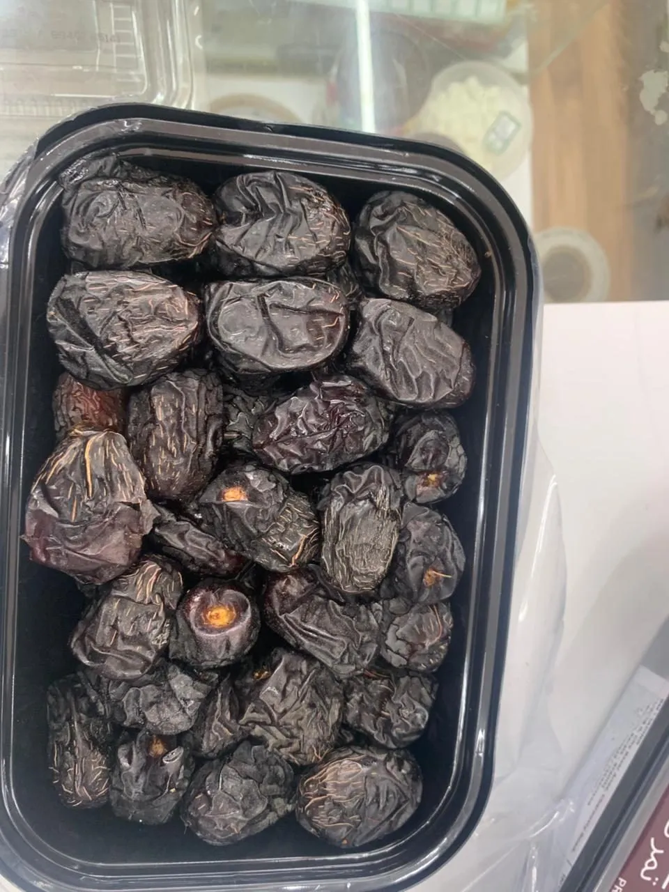 A black tray of dark Ajwa dates