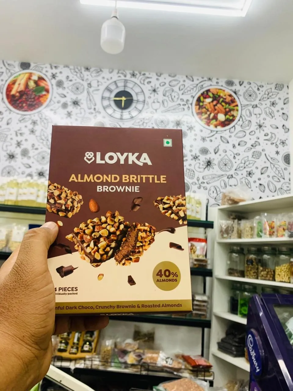Box of almond brittle brownie chocolates held up inside the shop