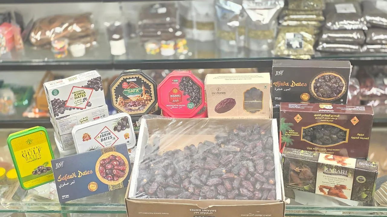 Boxes and tins of dates on a shelf with an open carton of dates in front