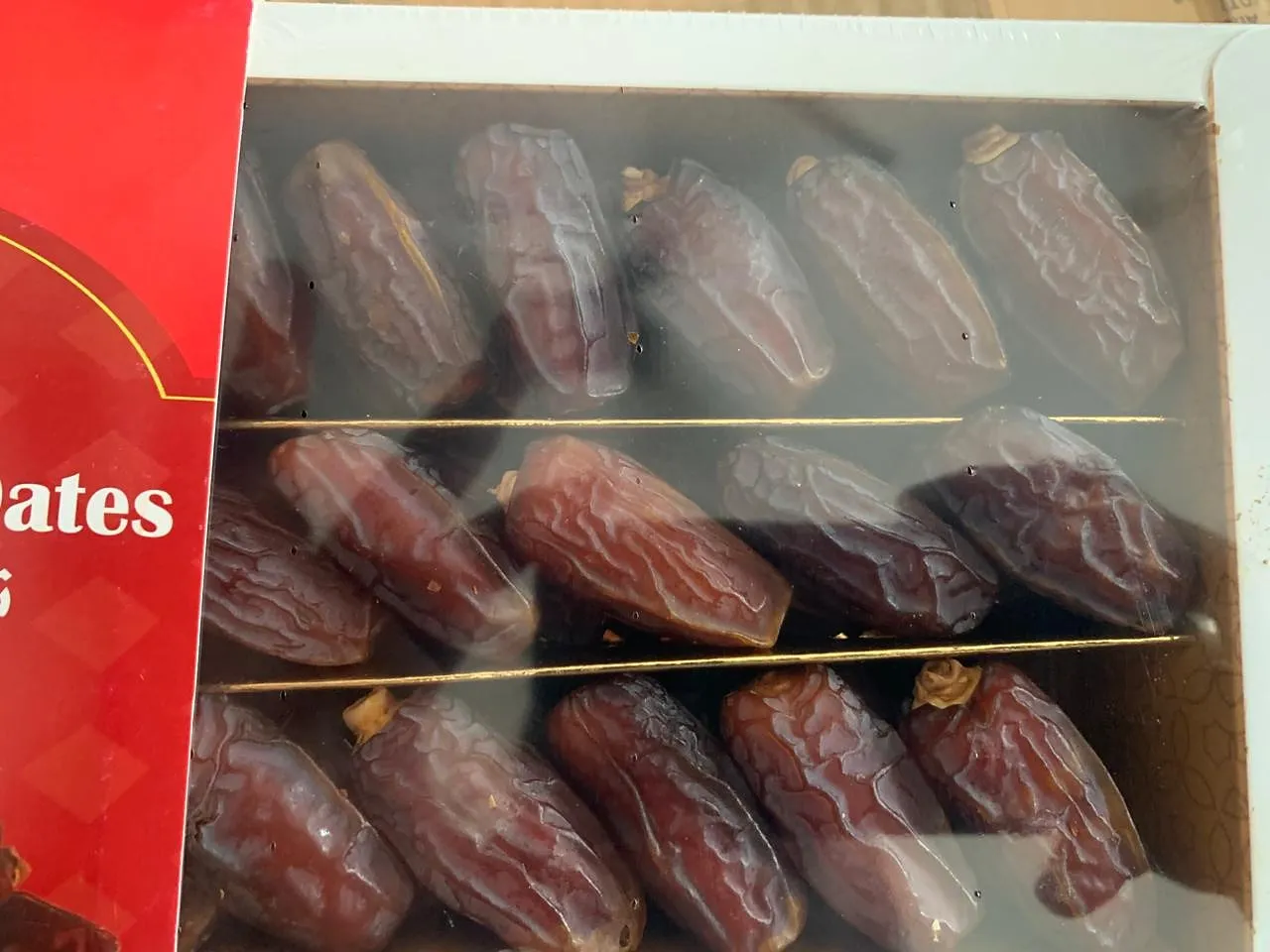 Close-up of dates arranged in rows inside a boxed pack