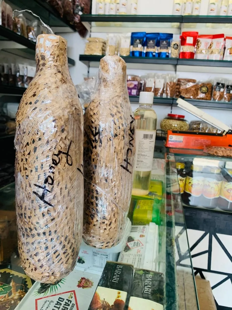 Two bottles of honey wrapped in woven paper