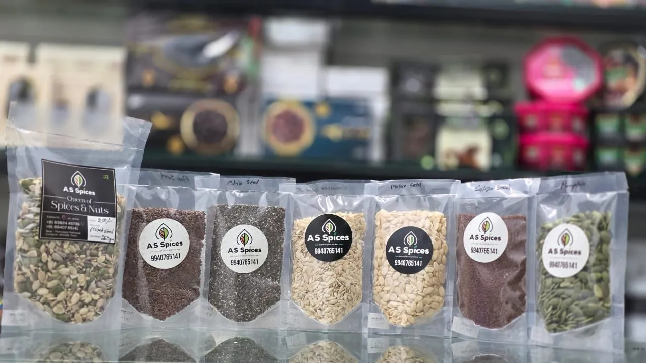 Clear pouches of seeds with A S Spices labels lined up on a counter