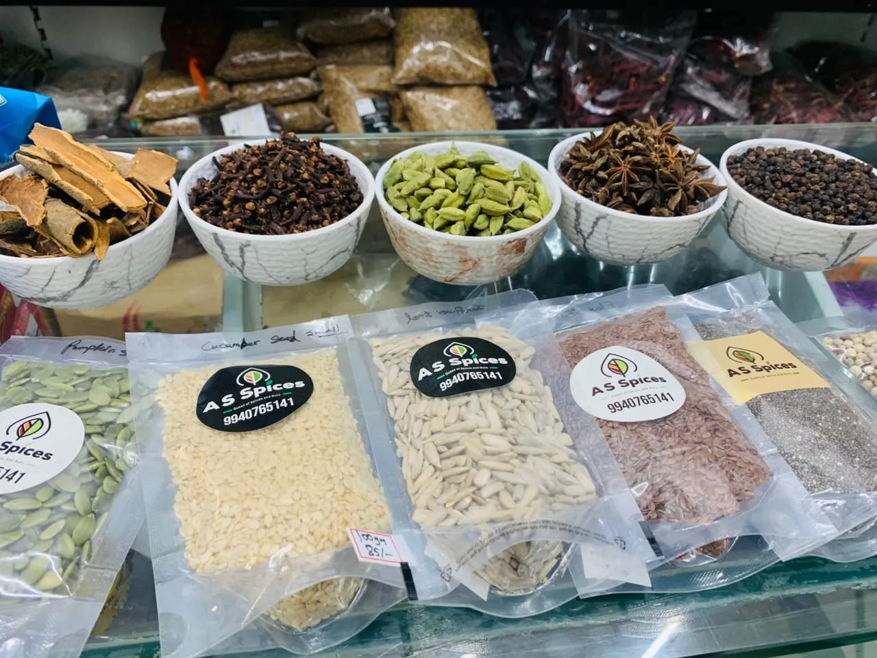 White bowls of cinnamon, cloves, cardamom, star anise and black pepper on the shop counter