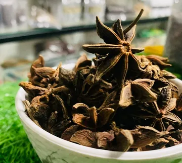 Star anise pods in a white bowl
