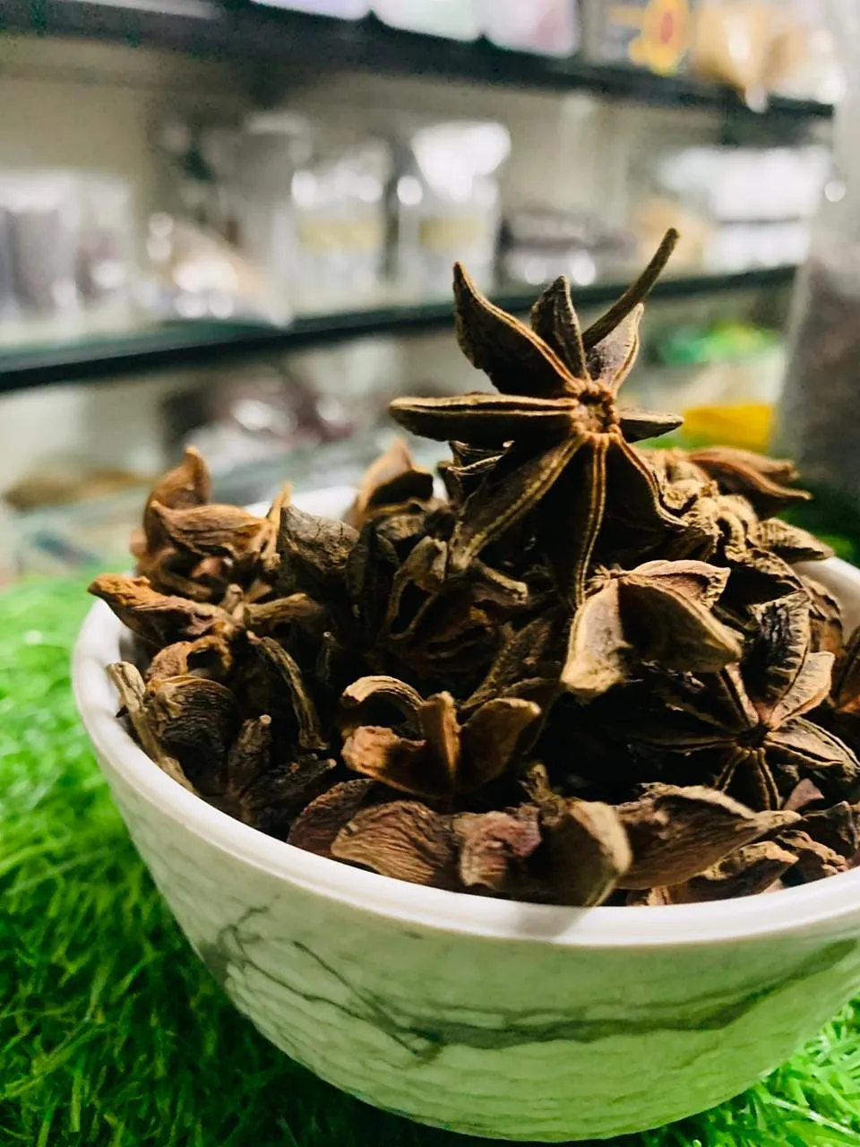 Star anise pods heaped in a white bowl